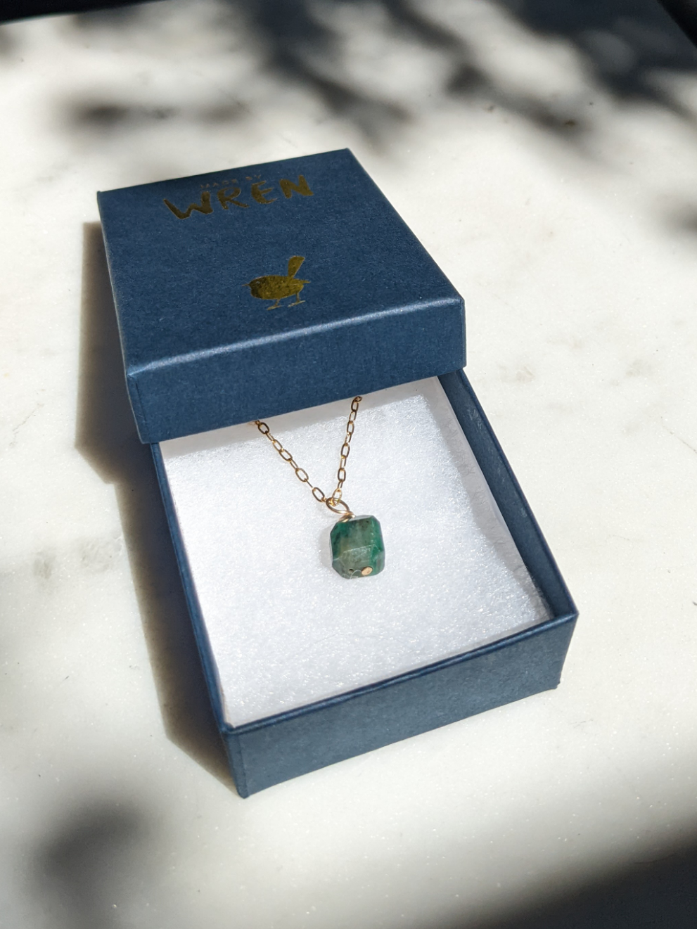 Emerald wire wrapped gold pendant