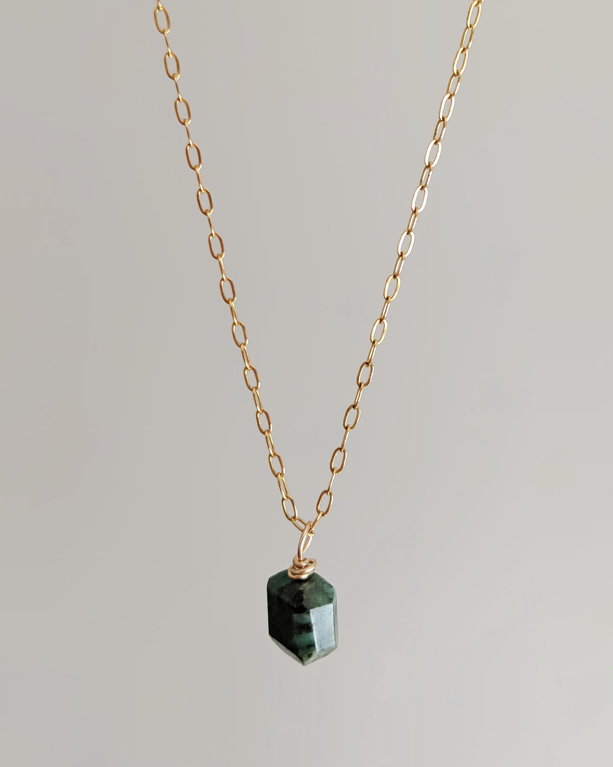 Emerald wire wrapped gold pendant